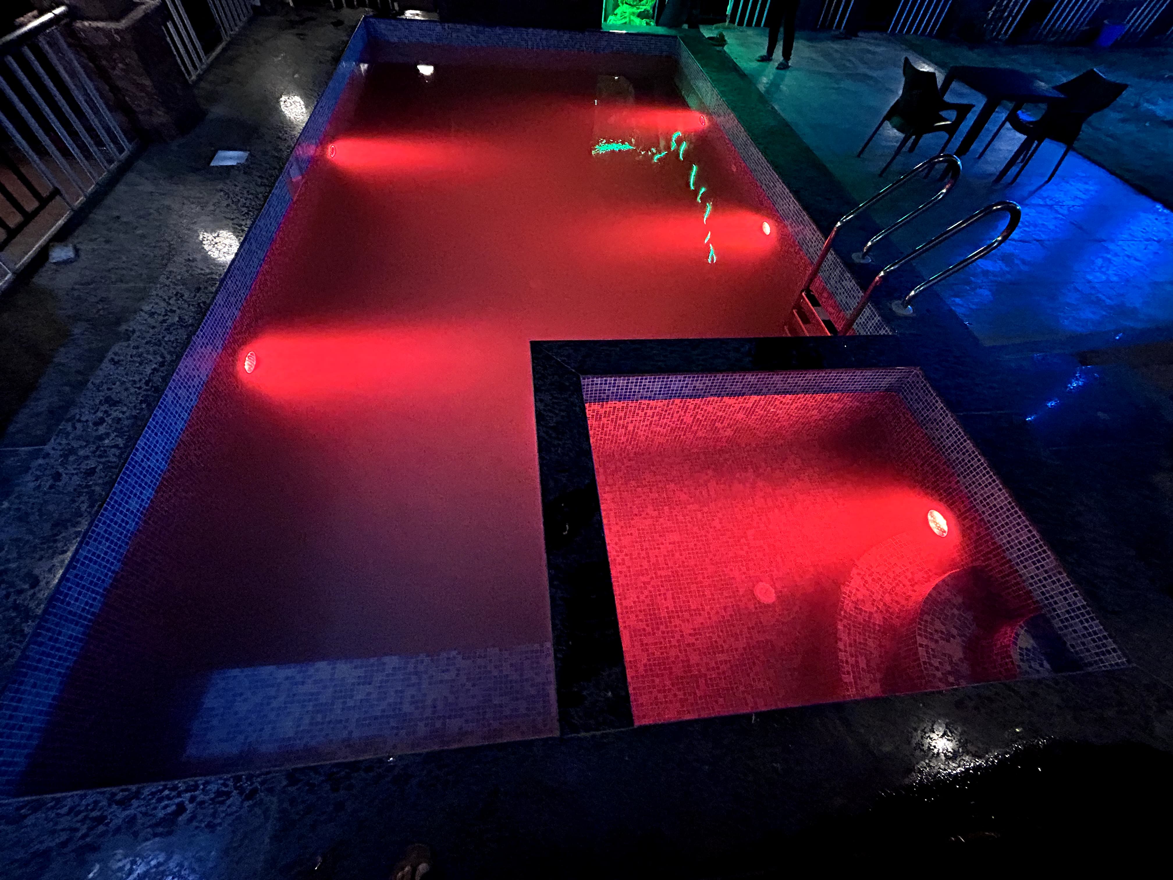 Private pool with colorful lights at night